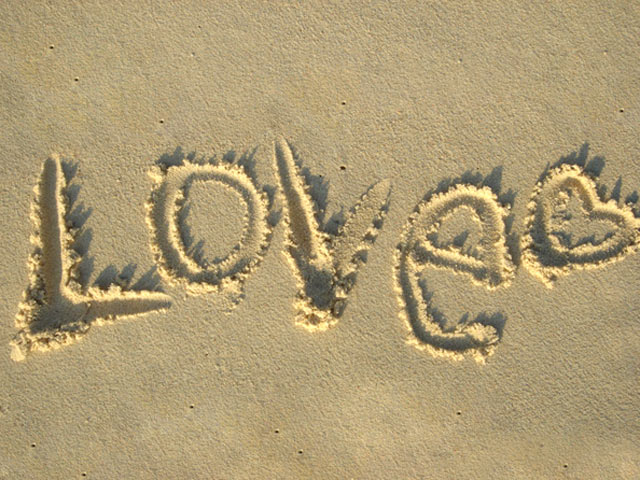 阳光下，沙滩的深沙地上写的LOVE字手机壁纸