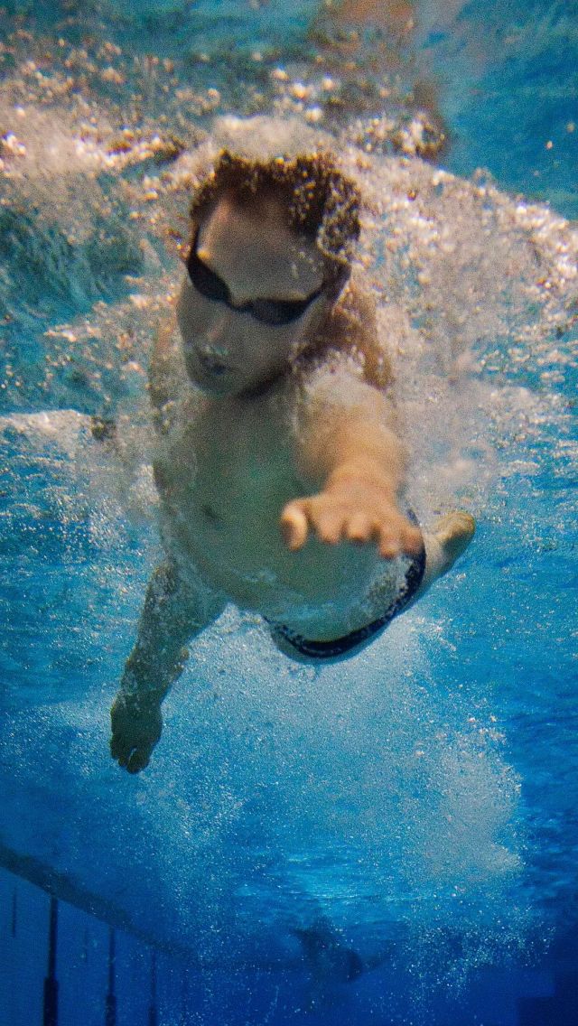 游泳选手头扎在水中，奋力向前划水的高清图片手机壁纸