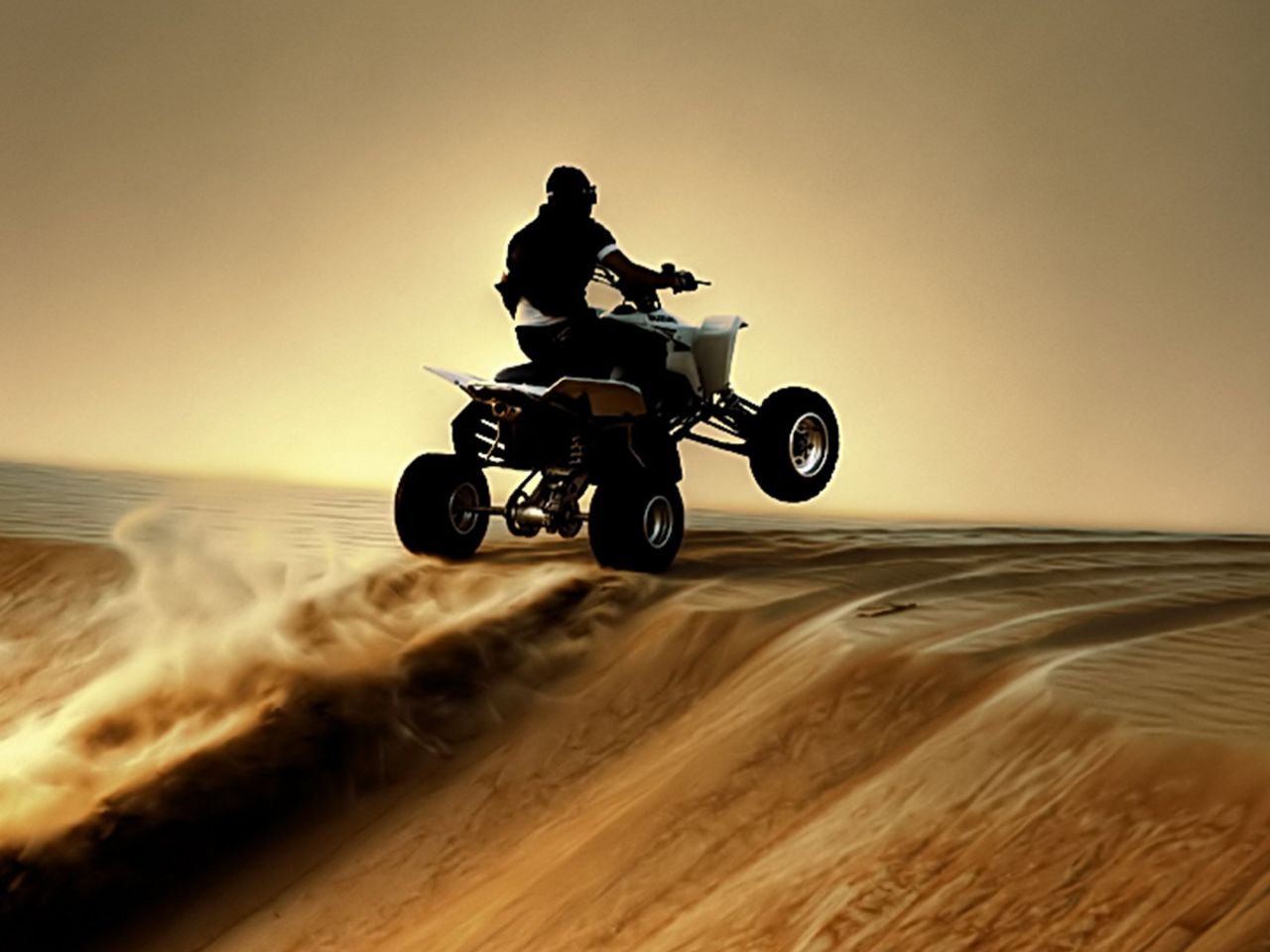 沙漠4轮摩托运动黄沙飞扬，轮子腾空手机壁纸图片