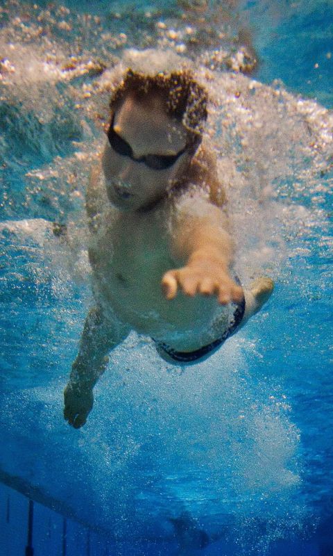 游泳选手头扎在水中，奋力向前划水的高清图片手机壁纸