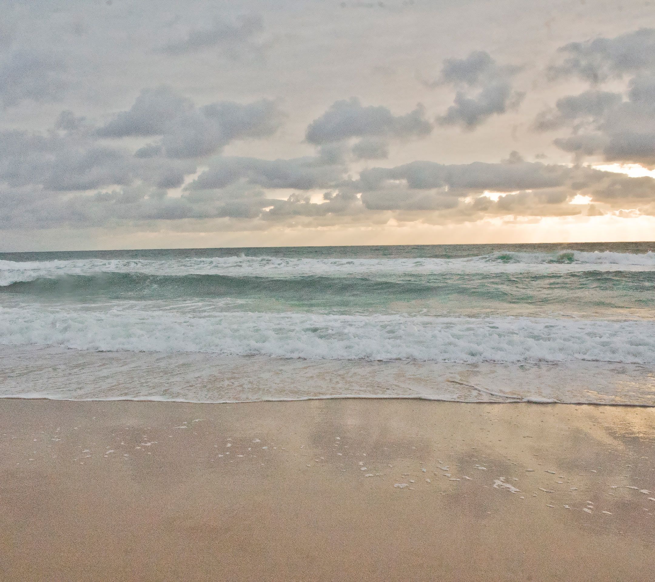 太阳躲在浮云后，海浪一下下拍打着沙滩高清手机壁纸1080