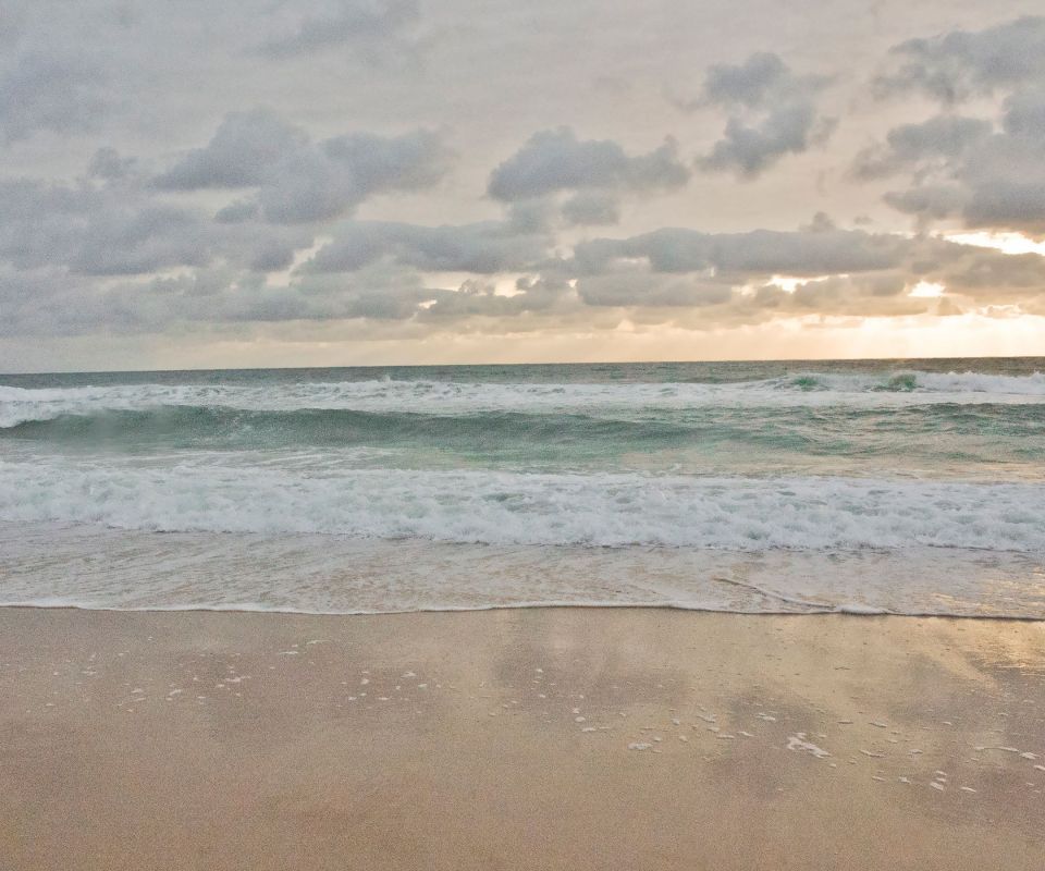 太阳躲在浮云后，海浪一下下拍打着沙滩高清手机壁纸1080