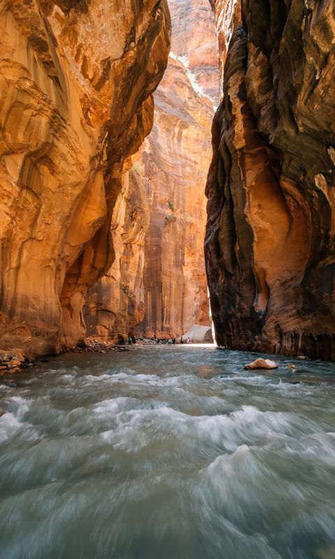 高高的陡峭石山间，水流很急的河水风景手机壁纸